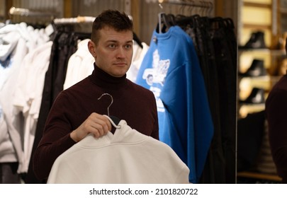 Photo Of A Man Choosing Clothes For Himself And As A Gift