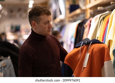 Photo Of A Man Choosing Comfortable Clothes In A Shopping Center For Himself And As A Gift