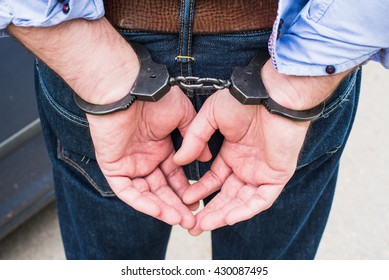 Photo of man in handcuffs.