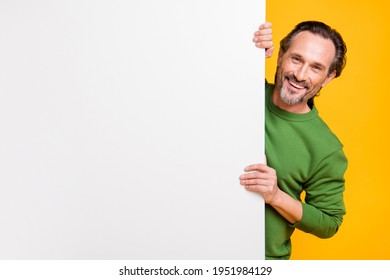 Photo Of Man Hide Behind White Placard Empty Space Look Camera Wear Green Sweater Isolated Yellow Color Background