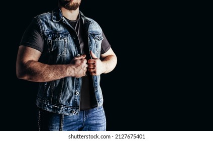 Photo Of Man In Jeans Shirt And Denim Biker Vest Standing On Black Background.