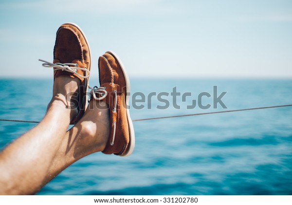 Photo of\
man legs on the yacht and wearing boat\
shoes