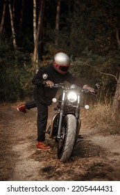 Photo Of A Man On A Motorcycle In The Forest. Vintage Background. Retro Wallpaper