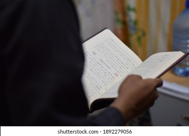 a photo of a man reading an Arabic book. Medina, Saudi Arabia. January 6, 2019.