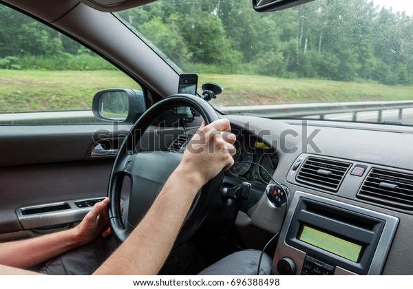 Photo of man sitting\
in car behind wheel