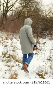Photo of a man walking through a snowy field