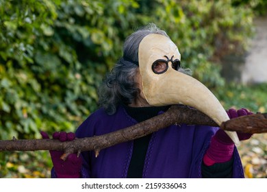 A Photo Of A Man Wearing An Ivory Beak Mask And A Costume Outdoors