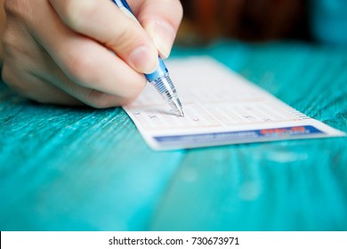 Photo Of Man's Hand With Pen And Lottery Ticket