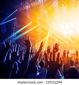 Photo of many people enjoying rock concert, crowd with raised up hands dancing in nightclub, audience applauding to musician band, night entertainment, music festival, happy youth, luxury party - Shutterstock ID 129152294