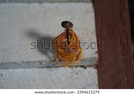photo of many rubber bands hanging on a nail.