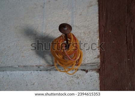photo of many rubber bands hanging on a nail.