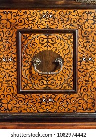 Photo of a marquetry cabinet worked with inlaid and carved wood.