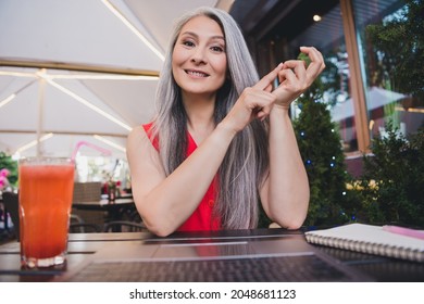 Photo of mature attractive asian business woman happy positive smile speak conversation webcam laptop cafe outdoors