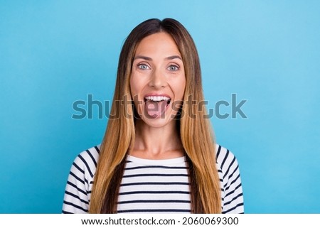 Photo of mature blond funky lady tongue out wear striped shirt isolated on blue color background