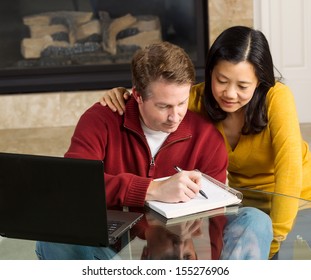 Photo of mature couple closely working together at home with fireplace in background   - Powered by Shutterstock