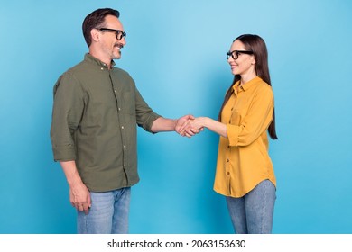 Photo Of Mature Happy Man And Woman People Wear Glasses Handshake Deal Isolated On Blue Color Background