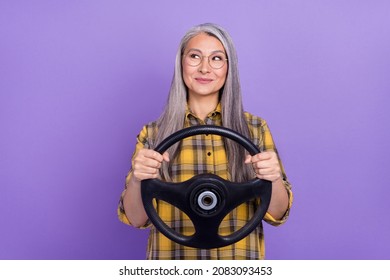 Photo of mature lovely woman drive auto transport look empty space dreamy isolated over purple color background - Powered by Shutterstock