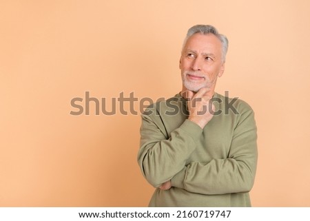 Photo of mature man hand touch chin wonder look empty space dream isolated over beige color background