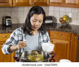 Photo Of Mature Woman Cooking Winter Melon From Steaming Pot With Large Spoon In Hand 