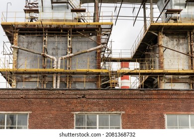 Photo of metal pipes next to a thermoelectric plant with big chimneys. Factory. Brick building.