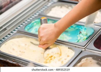 Photo Of A Metal Scoop Digging Into A Tub Of  Ice Cream.
