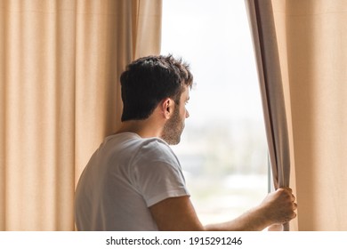 Photo of middle age bearded man looking in the window in the morning. - Powered by Shutterstock