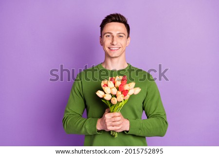 Photo of millennial nice brunet guy hold flowers wear sweater isolated on purple background