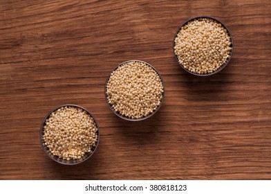 photo of millet in metal bowl on wooden table - Shutterstock ID 380818123