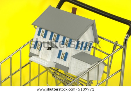 Photo of a Minature House in a Shopping Cart - Real Estate Concept