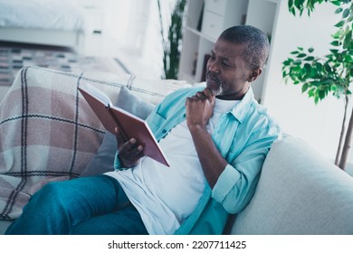 Photo Of Minded Aged Man Sit Comfy Divan Read Interesting Encyclopedia Think Idea In Modern Living Room