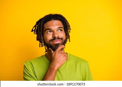 Photo of minded dark skin guy look empty space touch chin face think isolated over shine color background