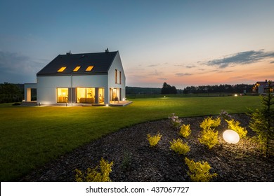 Photo of modern house with outdoor lighting, at night, external view