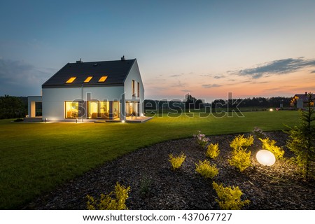 Photo of modern house with outdoor lighting, at night, external view