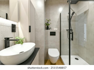 Photo of modern small bathroom with cashmere cabinets, LED-lit mirror, wall-hung toilet and shf modern small bathroom with cashmere cabinets, LED-lit mirror, wall-hung toilet and shower cubicle - Powered by Shutterstock