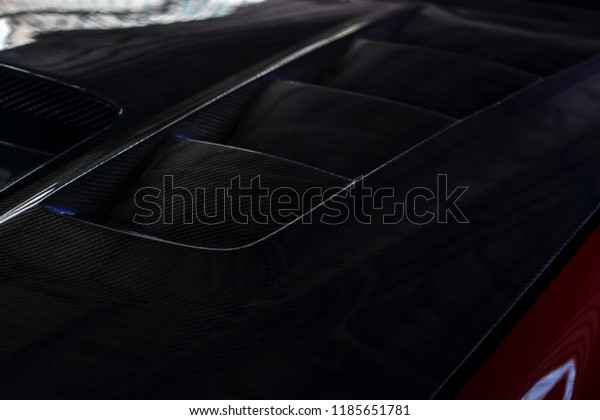 Photo of a modified carbonized car hood\
vents. Front view of a modified luxury\
car.