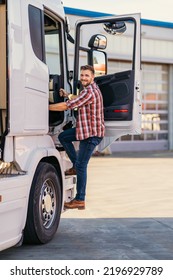 Photo Of Motivated Smiling Middle Aged Truck Driver Entering His Semi Truck Long Vehicle. Happy Trucker. Transportation Service.