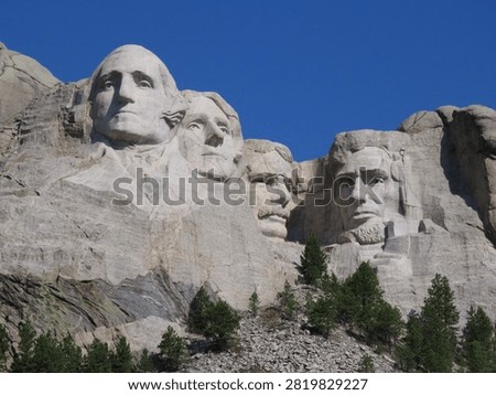 Photo of Mount Rushmore with Pine Trees Below and Brilliant Clear Blue Sky above