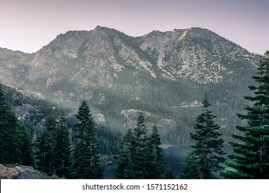 Photo of moutains around Emerald Bay in Lake Tahoe on border of California and Nevada with sunset sunrays coming from the left. 