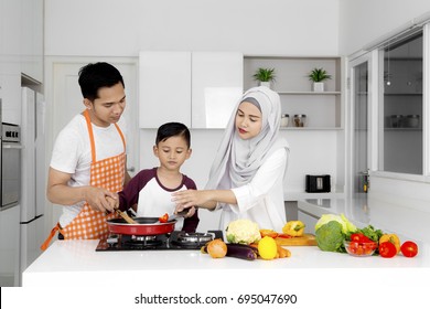 Photo Of Muslim Family Cooking Together While Preparing Food In The Kitchen