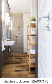 Photo Of A Narrow Bathroom With Floor Tiles Resembling Wood And Glass Shower Enclosure