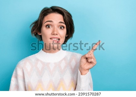 Photo of nervous girl panic which dress should buy first biting lips direct finger empty space boutique isolated on blue color background