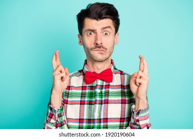 Photo Of Nervous Horrified Guy Crossed Fingers Bite Lip Wear Checkered Shirt Bow Isolated Blue Color Background