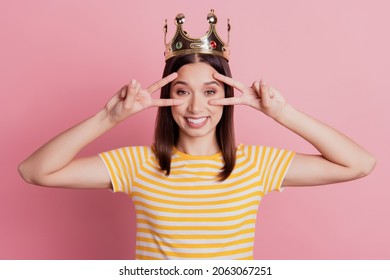 Photo Of Nice Attractive Lady Hands Show Two V-signs Cover Eyes Genuine Smile Wear Crown On Pink Background