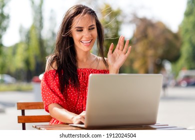 Photo Of Nice Brunette Charming Young Woman Wave Hello Camera Laptop Sit Outside In City Center Outdoors