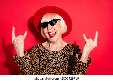 Photo Of Nice Charming Happy Crazy Old Lady Show Horned Signs Wear Hat Isolated On Red Color Background