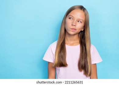 Photo Of Nice Cute Funny School Girl With Straight Hairdo Dressed White T-shirt Look Empty Space Isolated On Blue Color Background