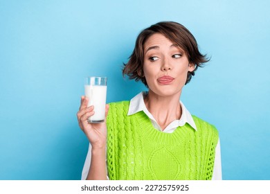 Photo of nice funny lady look hand hold fresh milk glass tongue lick lip isolated on blue color background