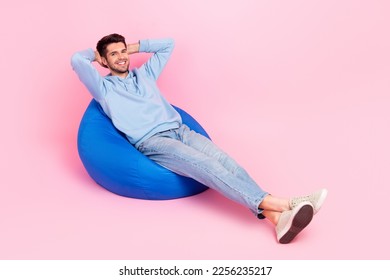 Photo of nice glad man sit comfy chair hold arms behind head rejoice free time weekend home empty space isolated on pink color background - Shutterstock ID 2256235217