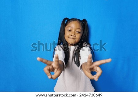 Photo of nice lovely adorable kid girl enjoy summer weekend make v-sign wear good look outfit isolated over blue color background