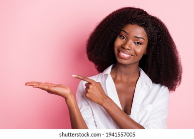 Photo of nice optimistic brunette hairdo lady hold point empty space wear white shirt isolated on pink color background